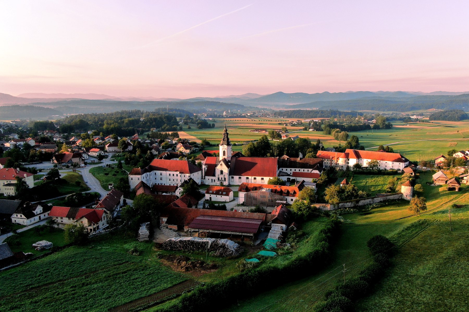 Cistercijanska opatija Stična iz zraka v zahajajočem soncu